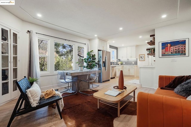 living room featuring sink and light hardwood / wood-style flooring