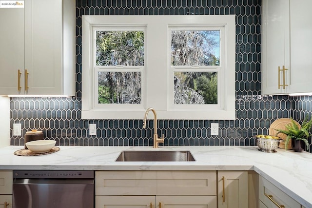 kitchen with sink, dishwasher, light stone counters, and backsplash