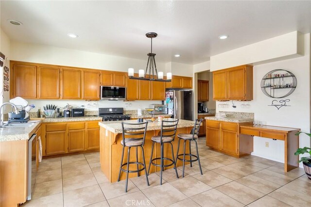 kitchen featuring sink, decorative light fixtures, light tile patterned floors, appliances with stainless steel finishes, and a kitchen island