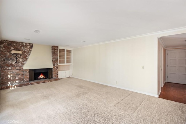 unfurnished living room featuring crown molding, a brick fireplace, carpet flooring, and built in features