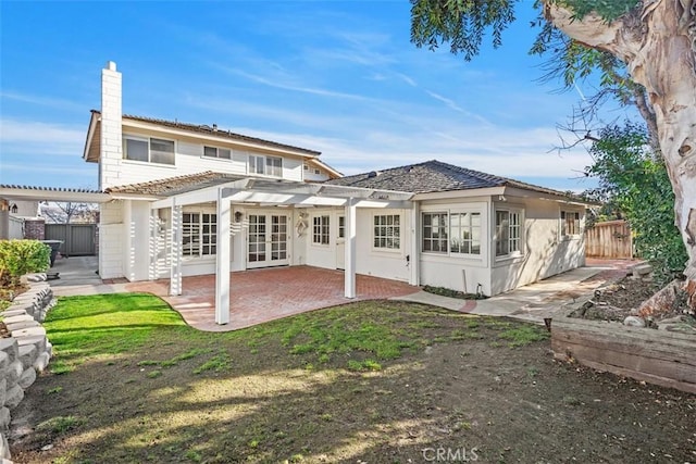 back of house with french doors, a pergola, a patio area, and a lawn