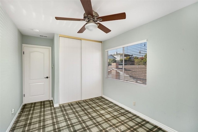 unfurnished bedroom with carpet floors, a closet, and ceiling fan