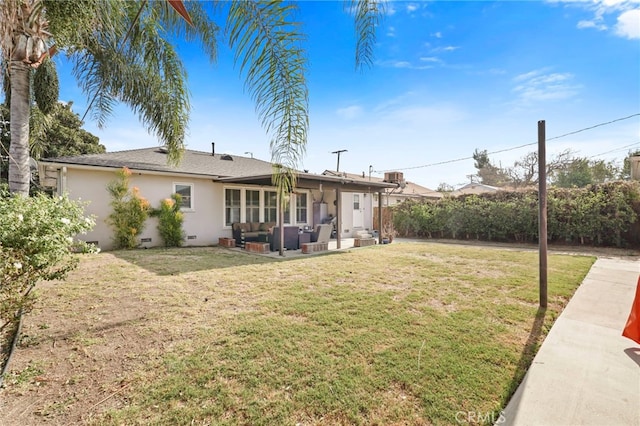 back of property with a yard and an outdoor hangout area