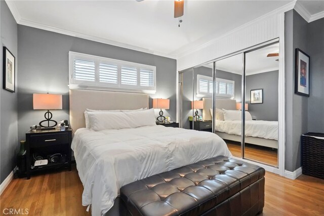 bedroom with crown molding, ceiling fan, hardwood / wood-style floors, and a closet