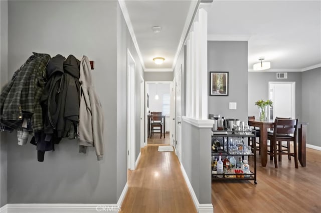 hallway featuring hardwood / wood-style flooring and ornamental molding