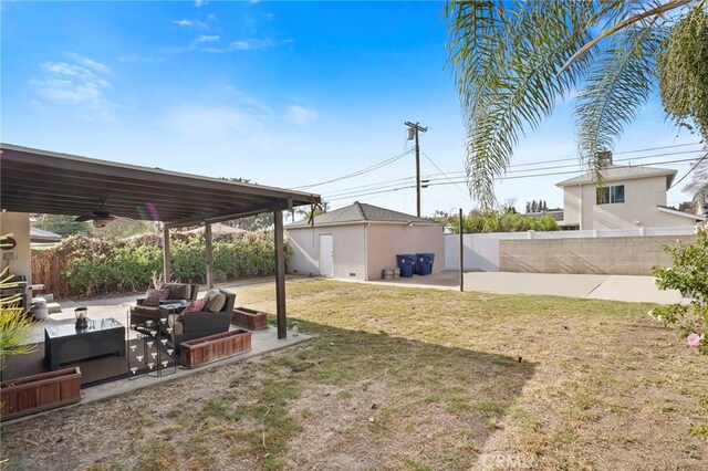 view of yard featuring ceiling fan, an outdoor living space, and a patio