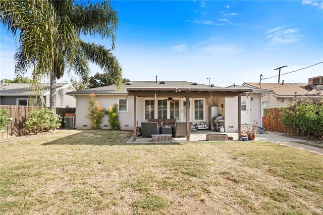 back of property with an outdoor living space, a lawn, a patio, and ceiling fan