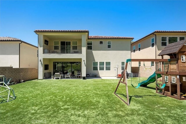 rear view of property with a yard, a patio area, and a playground