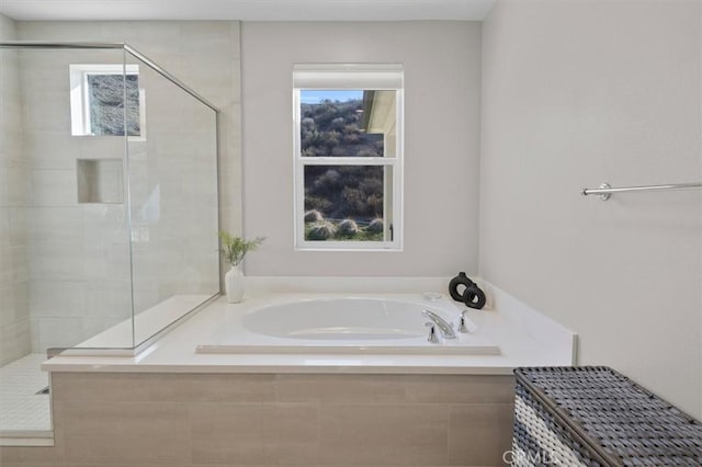 bathroom featuring plenty of natural light and separate shower and tub