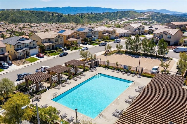 view of swimming pool featuring a mountain view, a pergola, and a patio area