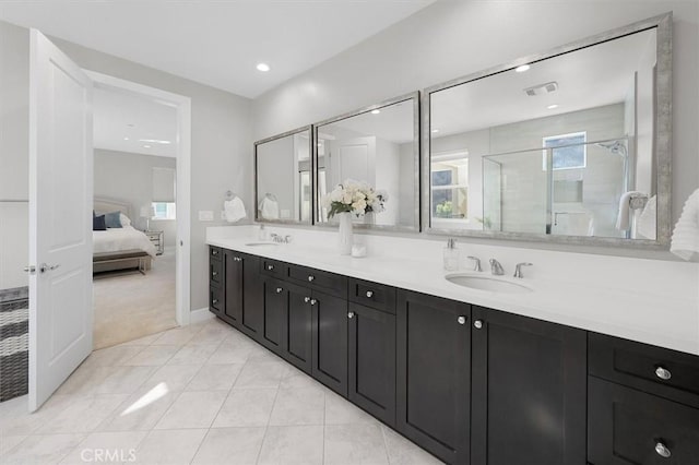 bathroom with tile patterned flooring, vanity, and walk in shower