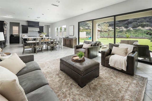 living area featuring light tile patterned floors, visible vents, and recessed lighting