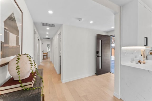 hallway with light hardwood / wood-style floors