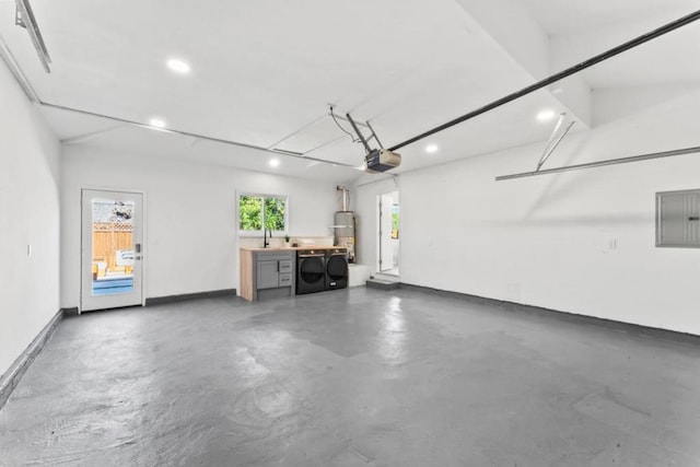 garage with secured water heater, a garage door opener, sink, washer and dryer, and electric panel