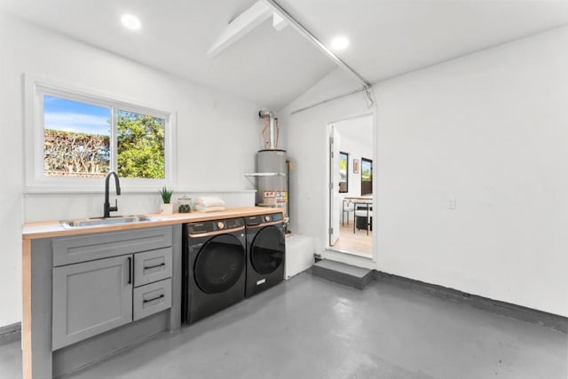 laundry area featuring sink, secured water heater, and separate washer and dryer