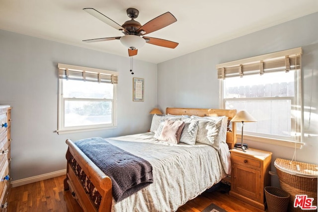 bedroom with multiple windows, dark hardwood / wood-style floors, and ceiling fan