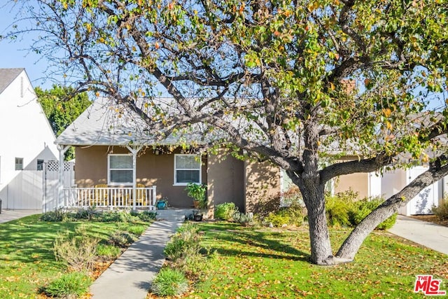 obstructed view of property featuring a front lawn and covered porch