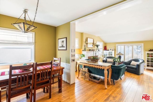 dining room featuring lofted ceiling and light hardwood / wood-style floors