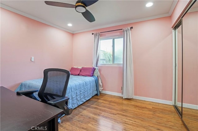 bedroom with a closet, ceiling fan, crown molding, and light hardwood / wood-style floors