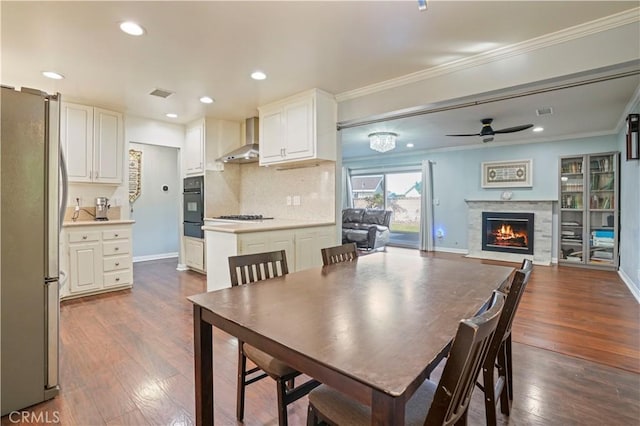 dining space with ceiling fan, ornamental molding, and dark hardwood / wood-style floors