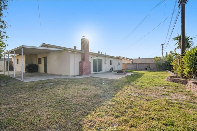 rear view of house featuring a yard and a patio