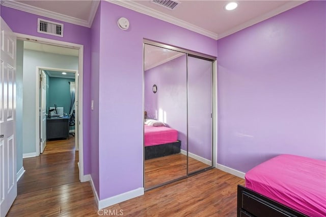 bedroom featuring hardwood / wood-style flooring, a closet, and ornamental molding