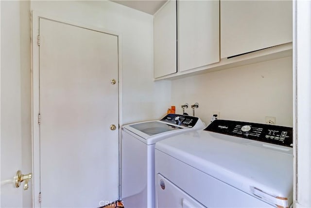 laundry room with cabinets and washing machine and clothes dryer