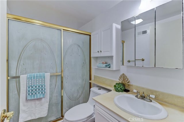 bathroom featuring vanity, toilet, and an enclosed shower