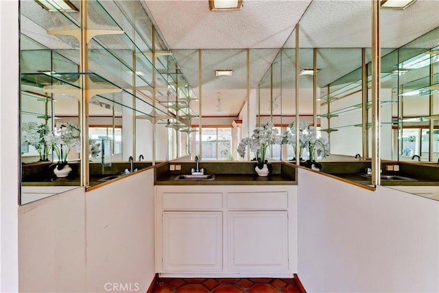 bar featuring sink and white cabinetry