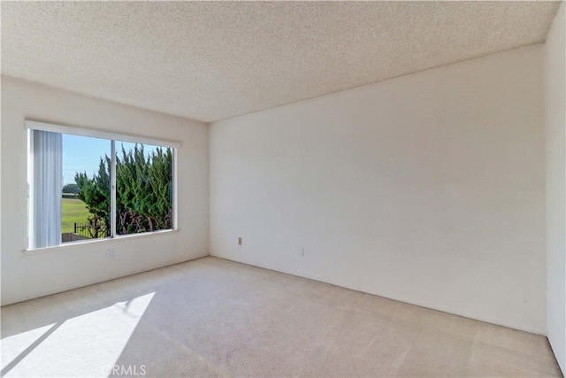 carpeted spare room with a textured ceiling