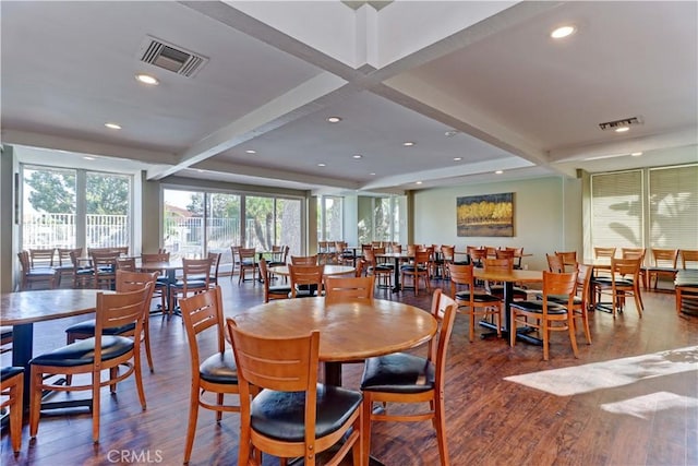 dining space featuring dark wood-type flooring and beamed ceiling