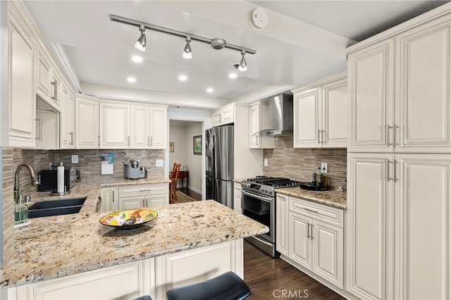 kitchen with sink, light stone countertops, appliances with stainless steel finishes, and wall chimney exhaust hood