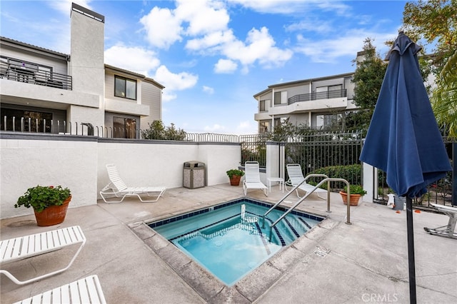 view of swimming pool featuring a community hot tub and a patio