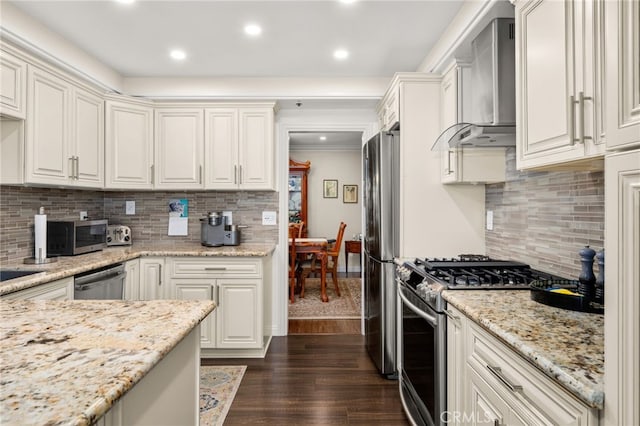 kitchen featuring white cabinets, dark hardwood / wood-style flooring, stainless steel appliances, decorative backsplash, and light stone counters