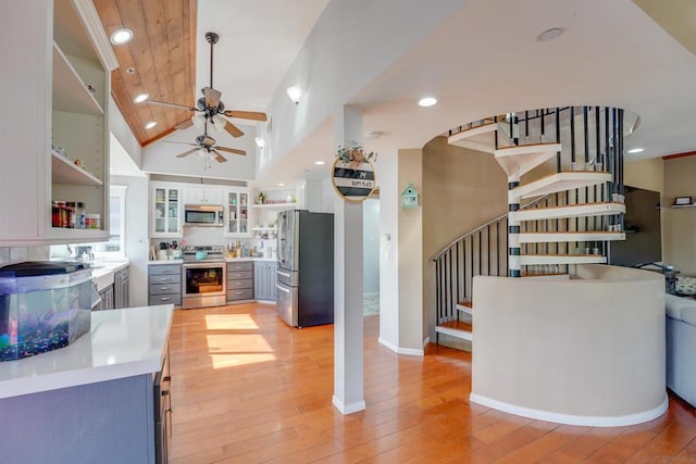 kitchen featuring stainless steel appliances, light hardwood / wood-style floors, high vaulted ceiling, ceiling fan, and gray cabinetry