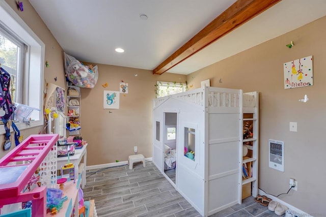 playroom featuring hardwood / wood-style flooring, beamed ceiling, and heating unit