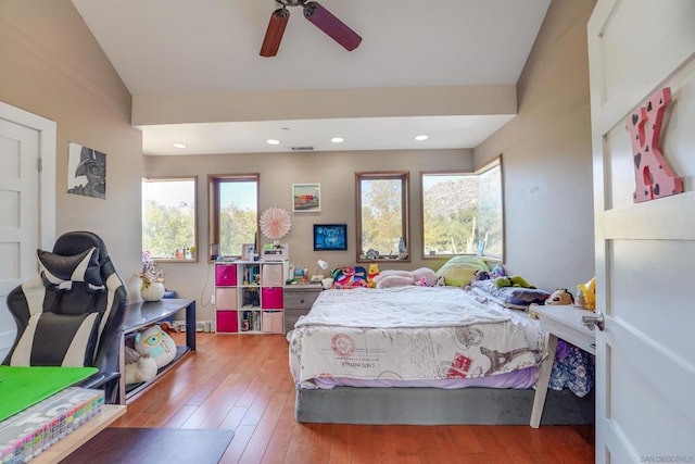 bedroom featuring ceiling fan, vaulted ceiling, hardwood / wood-style flooring, and multiple windows