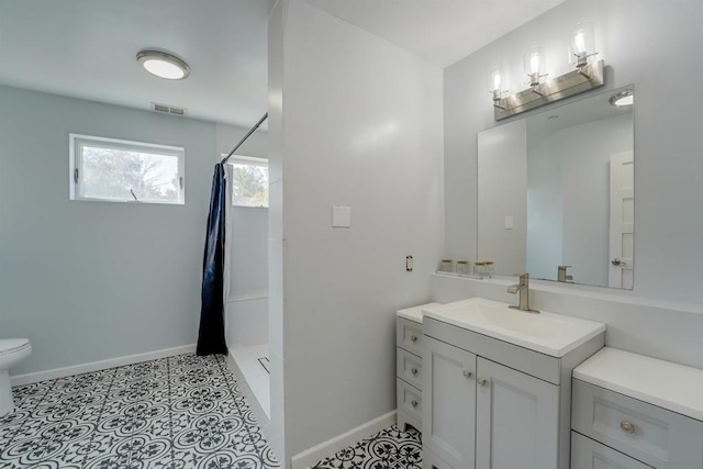 bathroom featuring toilet, vanity, and a shower with shower curtain