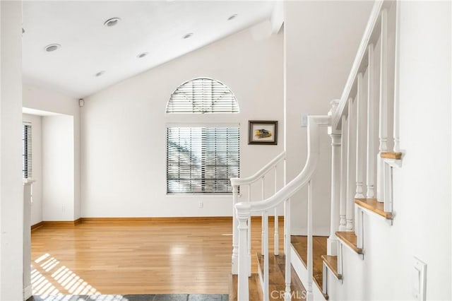 stairs featuring vaulted ceiling and hardwood / wood-style floors