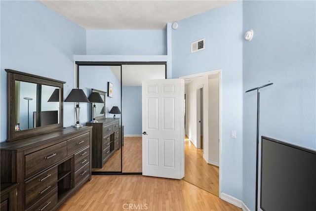 bedroom with light hardwood / wood-style floors and a closet