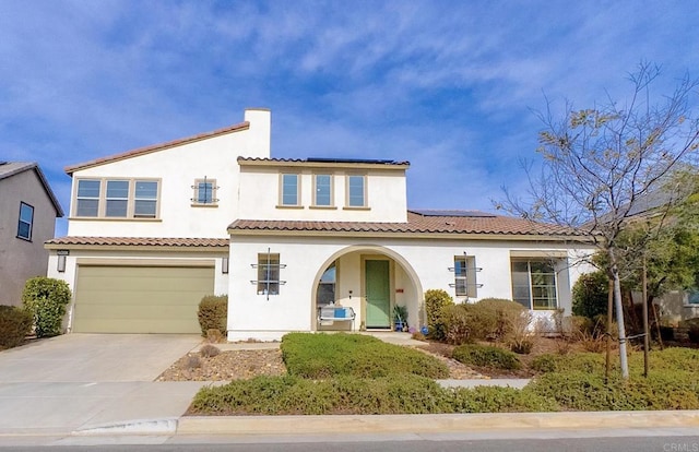 mediterranean / spanish home featuring a garage and solar panels