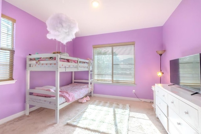 bedroom featuring multiple windows and light colored carpet