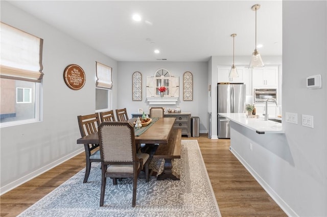 dining area with sink and light wood-type flooring