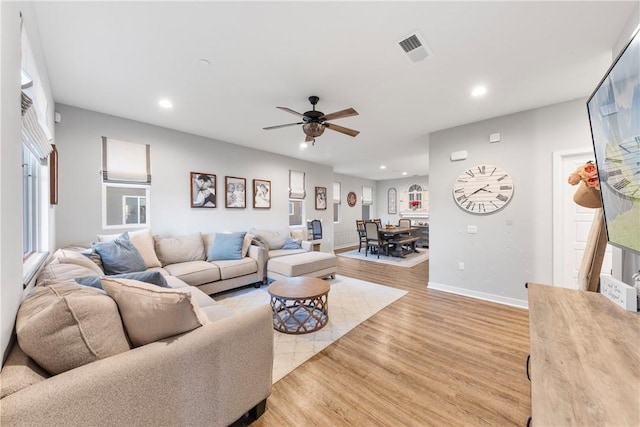 living room with ceiling fan and light hardwood / wood-style floors