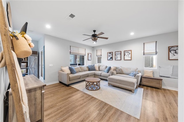 living room featuring light hardwood / wood-style floors and ceiling fan