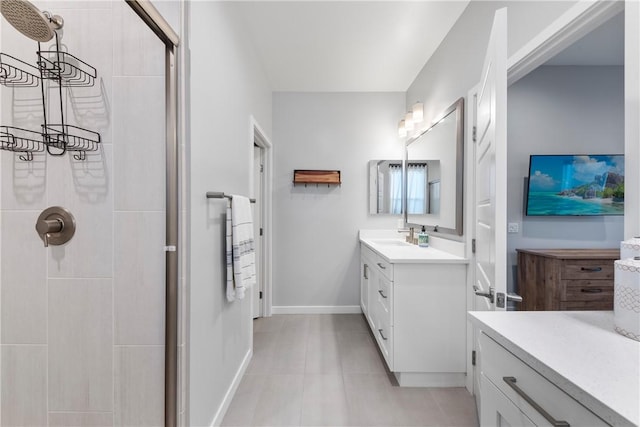 bathroom with vanity, a tile shower, and tile patterned flooring