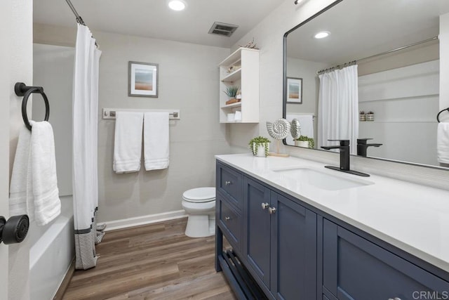 full bathroom featuring hardwood / wood-style floors, toilet, shower / bath combo, and vanity