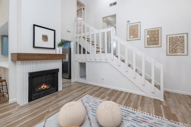 living room featuring light wood-type flooring and a high ceiling