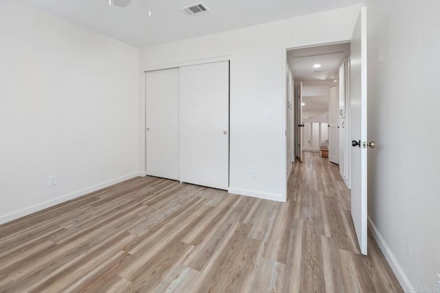 unfurnished bedroom with a closet and light hardwood / wood-style flooring