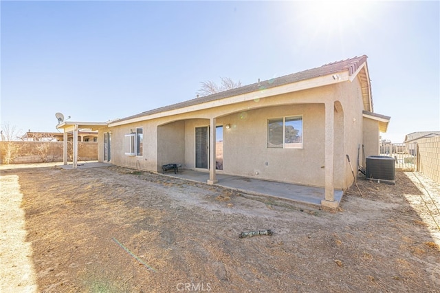 rear view of property with central AC